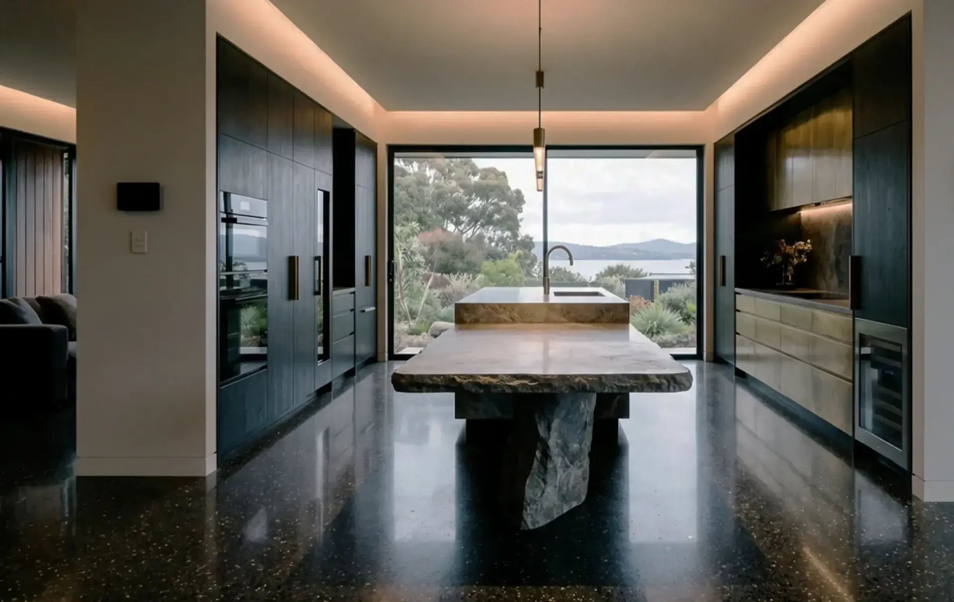 Custom dark timber kitchen with a stone island and a view over the Derwent
